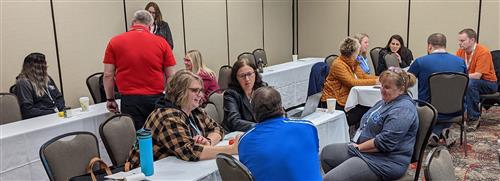 Conference attendees in active conversation at an IT2  breakout session